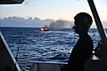 A crew member observes the fire aboard the fishing vessel Miss Emma